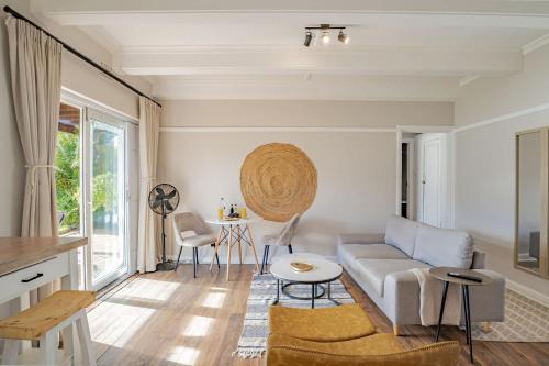 a living room with a couch and a table at Sunny Cove Stays in Fish Hoek