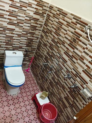a bathroom with a toilet and a scale on the floor at HIMALAYAN ESCAPE HOMESTAy in Sari