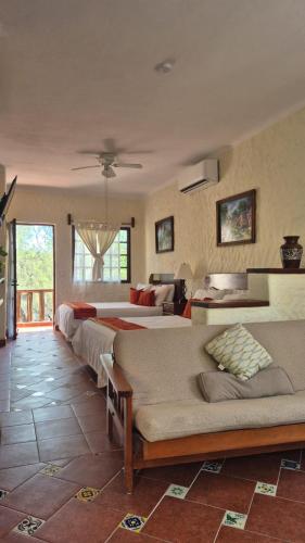 ein großes Zimmer mit zwei Betten und einer Couch in der Unterkunft Hotel Casa el Moro in Puerto Morelos