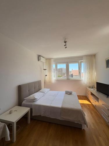 a bedroom with a large bed and a television at Charming studio with river view in Omiš