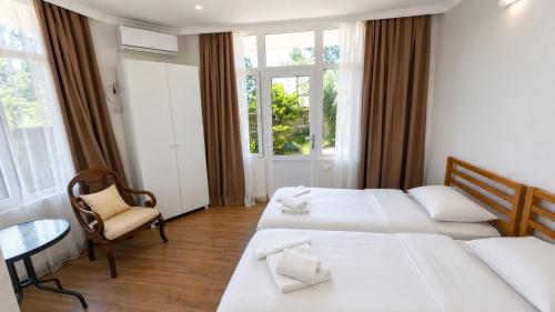 a hotel room with two beds and a chair at Villa TG for Large Families with Private Pool in Batumi