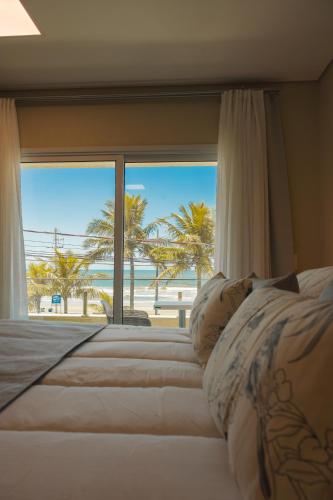 a bedroom with two beds with a view of the beach at Hotel VillaReal Charme in Guaratuba