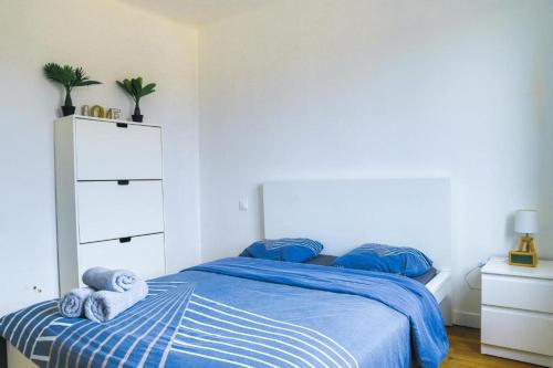 a bedroom with a bed with blue sheets and towels at Le KA NOE in Vaires-sur-Marne