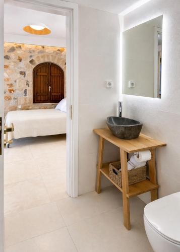 a bathroom with a sink and a bedroom at Papanestoras Apartments in Kardamyli
