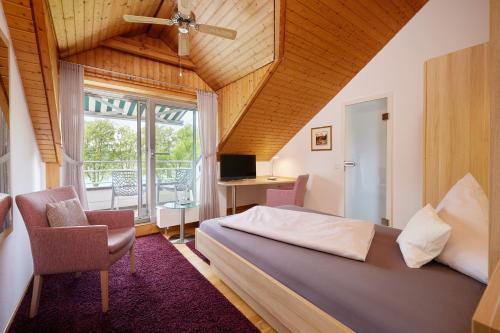 a bedroom with a bed and a desk and a window at Iris am See garni in Radolfzell am Bodensee