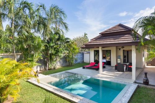 a backyard with a swimming pool and a house at Phuket Pool Residence - SHA Extra Plus in Rawai Beach