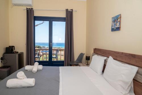 a bedroom with a bed with a view of the ocean at Adam in Falasarna