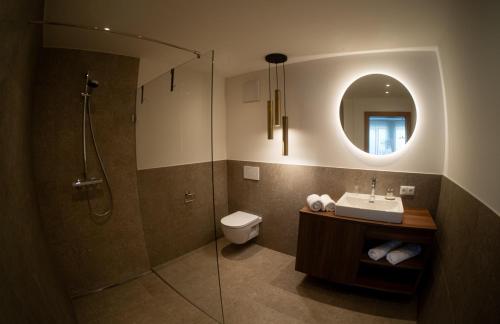 a bathroom with a sink and a shower and a toilet at Aparthaus Vergissmeinnicht in Söll