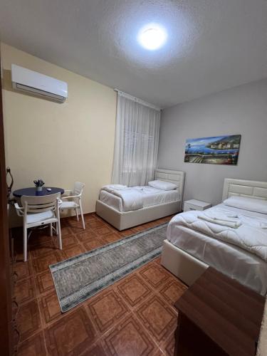 a hotel room with two beds and a table at Vila Beliz in Tirana