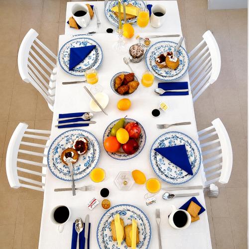 a white table with plates of food on it at Gennadi Villa Mare 300m from the Beach in Gennadi