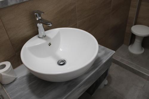 a white sink sitting on a counter in a bathroom at The Three anchors Rooms Perissa in Perissa
