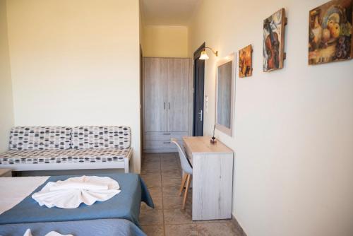 a bedroom with a bed and a desk and a table at Adam in Falasarna