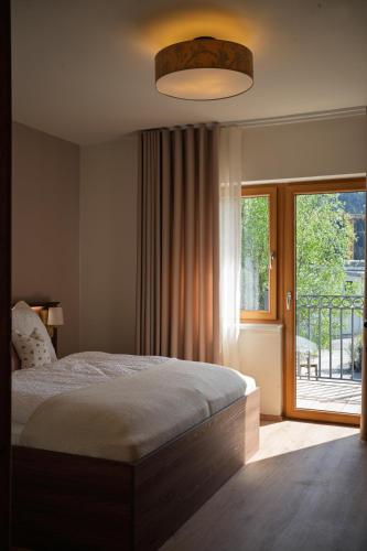 a bedroom with a bed and a large window at Aparthaus Vergissmeinnicht in Söll