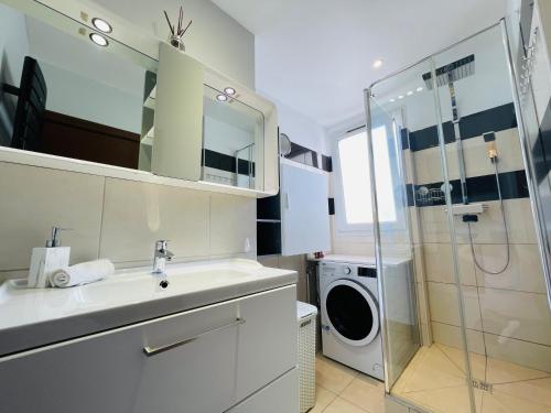 a bathroom with a sink and a washing machine at Bella Stay in Cannes