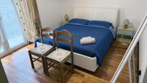 a bedroom with a bed and two chairs and a window at Casa Cretier in Aosta