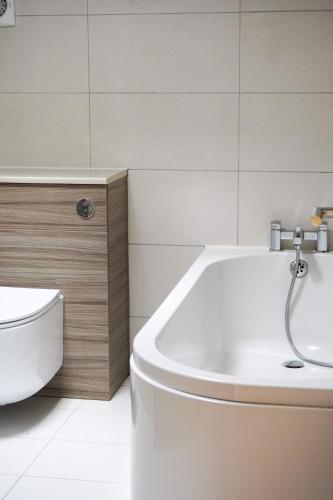 ein Badezimmer mit einer weißen Badewanne und einer Toilette in der Unterkunft Peak Edge Hotel in Chesterfield