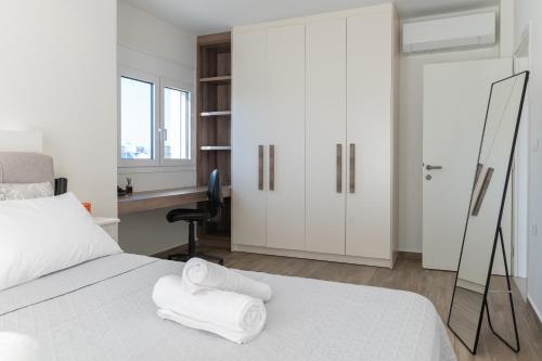 a bedroom with a white bed with towels on it at Casa John Kos Apartment in Zipárion