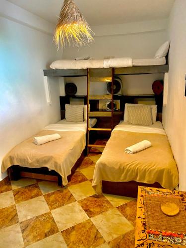 a room with two bunk beds and a checkered floor at Nizar Surf Morocco in Taghazout