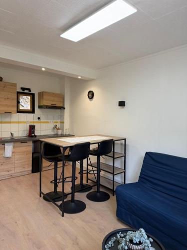 a living room with a table and two chairs at Appartement refait dans ancien hôtel restaurant in Saint-Uze