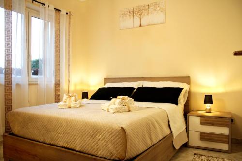a bedroom with a bed with two towels on it at L' Antico Scoglio Appartamenti comfort Nocera Terinese Scalo - Fino a 11 Ospiti - Piscina - Navetta Aeroporto-Stazione & Multi-Destinazioni - Spiaggia a 300mt - Giardino e Zona pranzo all'aperto - WiFi & SmartTV - Aria Condizionata in Nocera Terinese