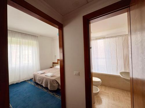 ein Schlafzimmer mit Bett und ein Badezimmer mit Toilette in der Unterkunft Quality Hotel Nova Domus in Rom