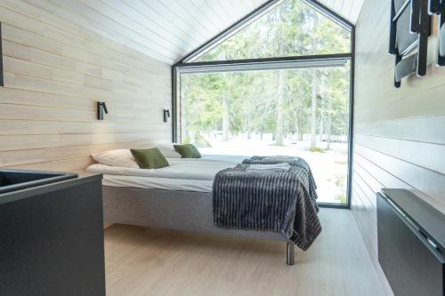 a bedroom in a tiny house with a window at Arctic Nest Forest Cabin in Kotila