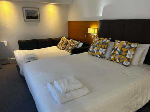 a bedroom with a large white bed and a couch at Holiday Inn Kenilworth - Warwick by IHG in Kenilworth