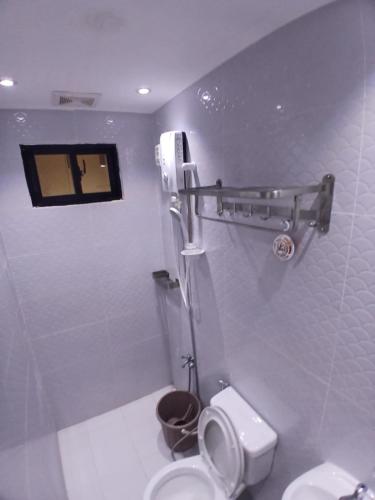 ein weißes Badezimmer mit Toilette und Dusche in der Unterkunft Marcus Tiny House - Aesthetic in Cabanatuan City in Bangad