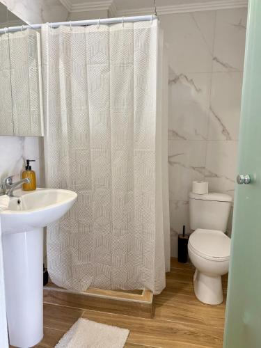 a bathroom with a toilet and a shower curtain at Villa Athina BC in Serres