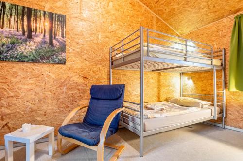 a bedroom with a bunk bed and a chair at Bungalows im Grünen in Lychen