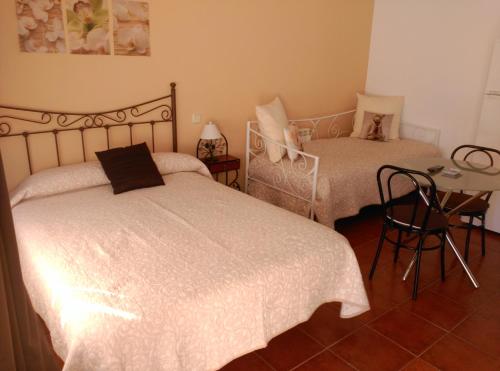 um quarto com duas camas e uma mesa e uma mesa em Hostal Restaurante "El Cercao" em Saúca