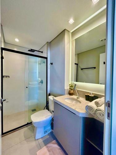 a bathroom with a toilet and a sink and a shower at Facilidade no Coração da Cidade in Campo Grande