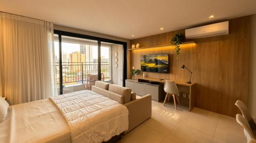 a bedroom with a large bed and a large window at Facilidade no Coração da Cidade in Campo Grande