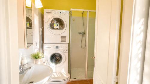 a bathroom with a washing machine and a sink at Ca la Genoveva in Montsonis
