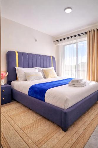 a large bed with a blue headboard in a bedroom at Ongata Rongai Pool Studio Near Nairobi National Park and giraffe center in Ongata Rongai 