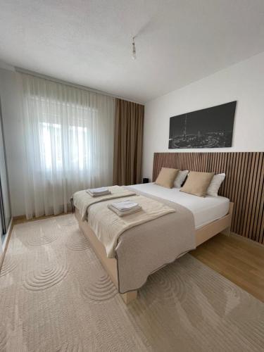 a bedroom with a large bed and a large window at House and pool BajNa in Mostar