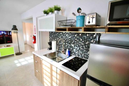 a kitchen with a sink and a refrigerator at 1.1• Disabled • Generator • 1st Floor • Parking in Mayaguez