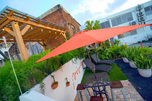 a patio with an umbrella and chairs and plants at 1.7 • Balcony • Generator • Parking • 2nd Floor in Mayaguez