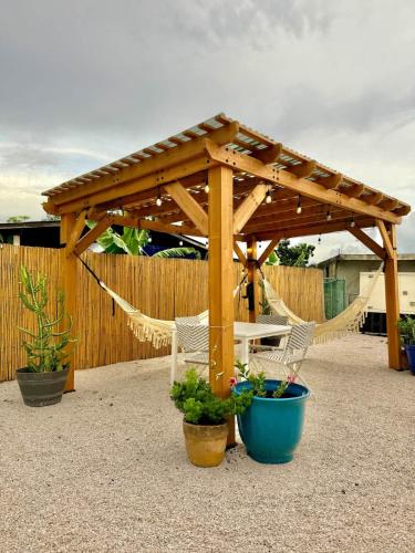 a wooden pergola with two chairs and a hammock at 3.6 Near Beach • Generator • Hammock • 2nd floor in Garita
