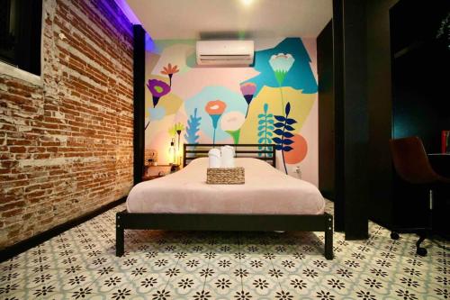 a bedroom with a bed and a wall with flowers at 5.3 Loft • Lobby • Generator • Parking • 2nd Floor in Mayaguez