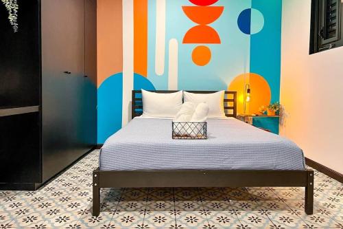 a bedroom with a bed with a colorful wall at 5.5 Loft • Lobby • Generator • Parking • 2nd Floor in Mayaguez
