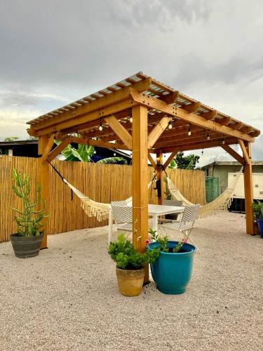 a wooden pergola with two chairs and a hammock at 3.9 Near Beach • Generator • Hammock • 1st Floor in Garita