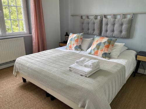 a bedroom with a large white bed with towels on it at Maison Boulvern in Plomodiern