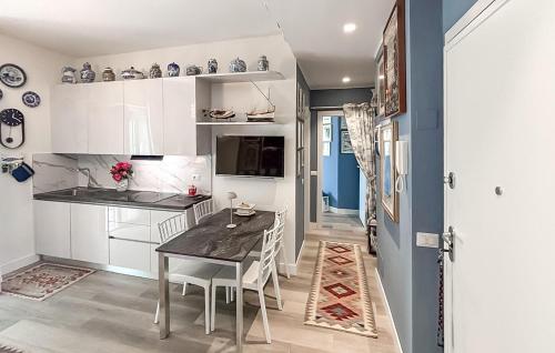 a kitchen with white cabinets and a dining table at 2 Bedroom Awesome Apartment In Chiavari in Chiavari