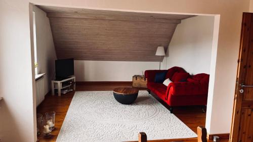 a living room with a red couch and a tv at Die Ferienwohnung im Grünen in Lichtenau
