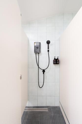 a bathroom with a shower stall with a hose at Yoosabai Hostel And Guesthouse in Bangkok
