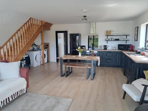 a living room with a table and a kitchen at Muckish Hideaway in Crockglass