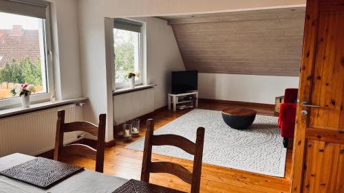 a living room with a table and chairs and a television at Die Ferienwohnung im Grünen in Lichtenau