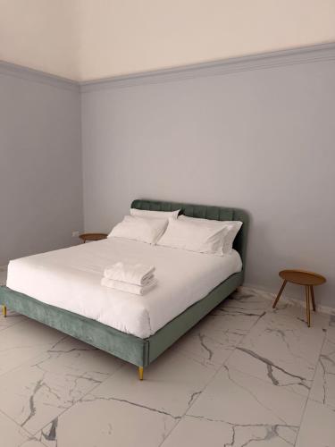 a bed with white sheets and pillows in a bedroom at Vulcano Rooms 2 in Catania