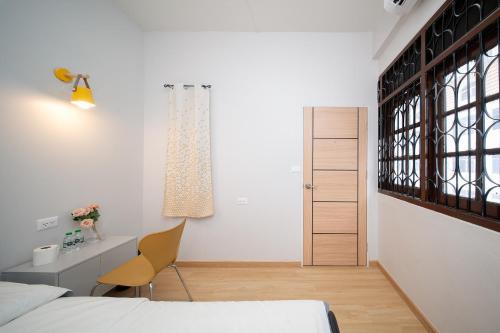 a bedroom with a bed and a desk and a chair at Yoosabai Hostel And Guesthouse in Bangkok